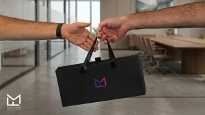 Two business partners exchanging a branded Magic Flavours bag in an office, representing shisha flavor partnership