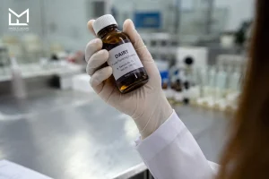 Lab sample bottle of dairy flavor essence held for scale-up testing evaluation